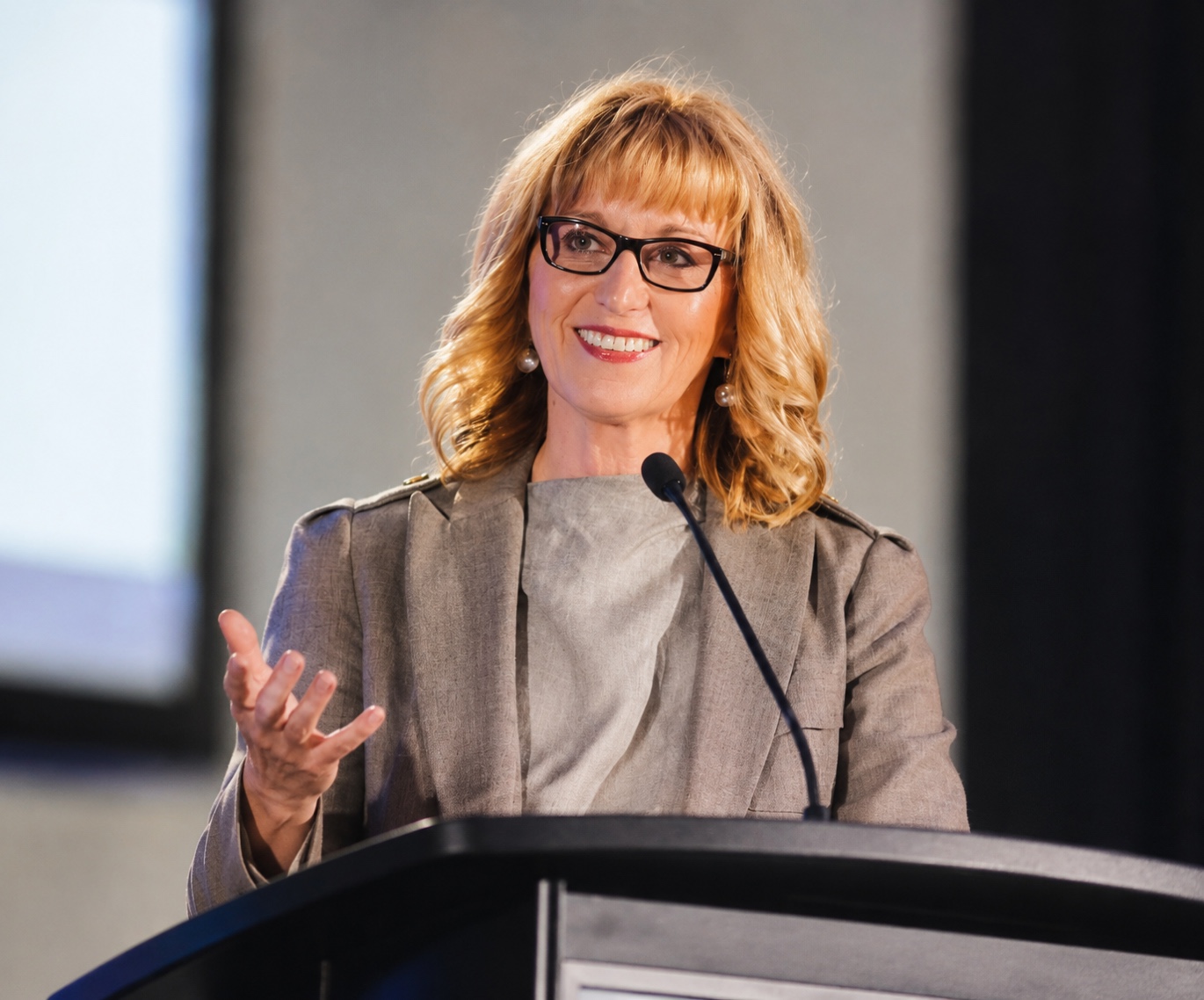 Esther Findlay speaking at a podium.